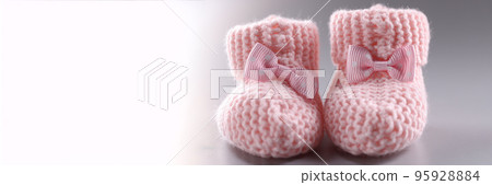 Handicraft shoes for newborn baby on grey background Handicraft shoes for newborn baby on grey background 95928884