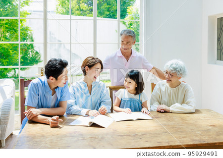 Family watching over elementary school students studying at home 95929491