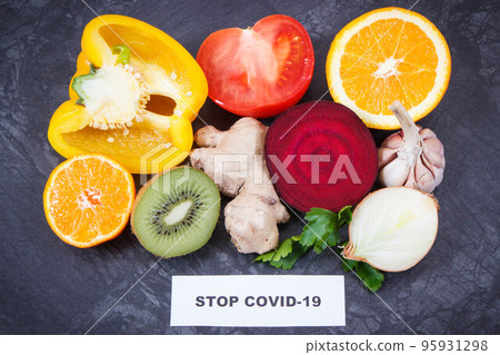 Inscription stop covid-19 and fresh healthy fruits with vegetables containing vitamins Inscription stop covid-19 and fresh healthy fruits with vegetables containing vitamins 95931298