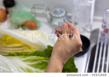 Sprinkling salt on Chinese cabbage to make Chinese cabbage kimchi at home Sprinkling salt on Chinese cabbage to make Chinese cabbage kimchi at home 95931689