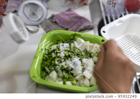 在廚房用鹽醃蘿蔔和蘿蔔葉 95932249