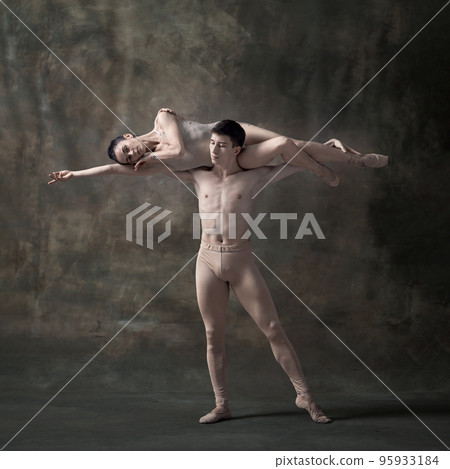Young man and woman, ballet dancers performing isolated over dark green vintage background. Lying on shoulders Young man and woman, ballet dancers performing isolated over dark green vintage background. Lying on shoulders 95933184