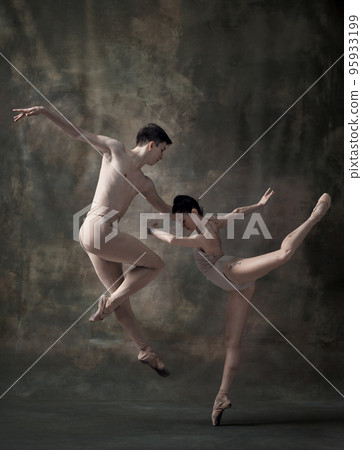 Young man and woman, ballet dancers performing isolated over dark green vintage background. Impressive tandem Young man and woman, ballet dancers performing isolated over dark green vintage background. Impressive tandem 95933199