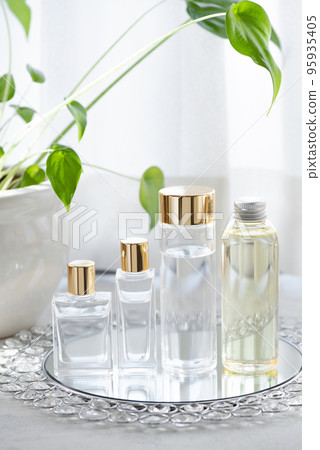 Four cosmetic bottles, glass and plastic, lined up by the window 95935405
