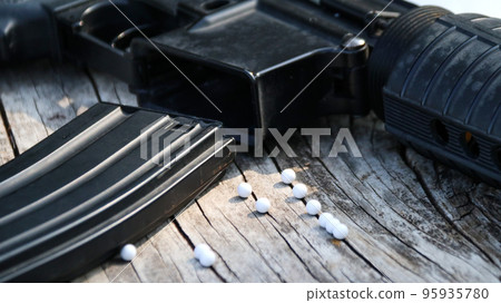 Close up some parts of airsoft gun or bb gun on wooden floor, soft and selective focus on airsoft gun 95935780