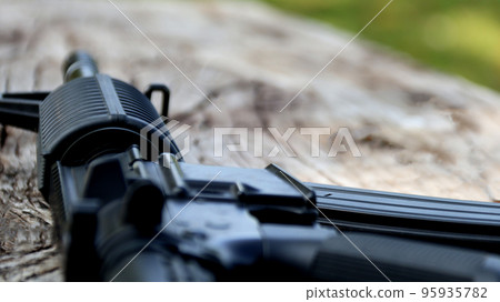 Close up some parts of airsoft gun or bb gun on wooden floor, soft and selective focus on airsoft gun Close up some parts of airsoft gun or bb gun on wooden floor, soft and selective focus on airsoft gun 95935782