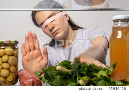 Losing weight vegetarian girl refuses meat sausages and takes green parsley and onions. Losing weight vegetarian girl refuses meat sausages and takes green parsley and onions. 95936416