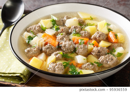 Satisfying sodd is Norway national dish which usually consists of mutton, meatballs, carrots, and potatoes served in a clear, fragrant broth closeup in the plate. Horizontal 95936559