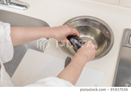 【中年家庭主婦將切好的圓茄子泡在水中去除鹼液】 95937036