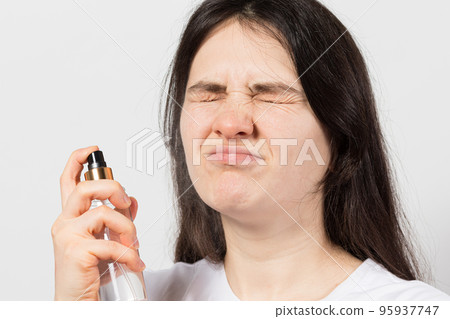 A woman splashes a tonic in her face. funny squints. Facial and neck skin care. A woman splashes a tonic in her face. funny squints. Facial and neck skin care. 95937747