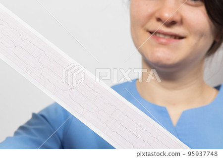 The cardiologist shows the film of an electrocardiogram of a patient with acute myocardial infarction. Heart and cardiovascular disease, cardiology and cardiography The cardiologist shows the film of an electrocardiogram of a patient with acute myocardial infarction. Heart and cardiovascular disease, cardiology and cardiography 95937748