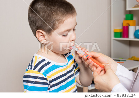 The pediatrician or nurse gives the child syrup in a measuring syringe. Treatment of cough, temperature in children. Paracetamol or ibuprofen for toddlers and preschoolers in pediatrics The pediatrician or nurse gives the child syrup in a measuring syringe. Treatment of cough, temperature in children. Paracetamol or ibuprofen for toddlers and preschoolers in pediatrics 95938124