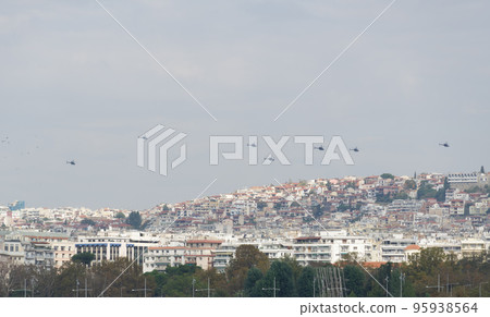 Air Force helicopters flying in formation above a city. HAF Air show in Thessaloniki, Greece during the 28 October National Oxi Day parade. 95938564