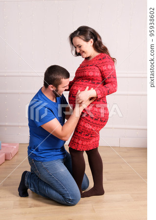 Happy future parents are expecting the birth of a baby, the husband strokes the belly of his pregnant wife, vertical photo. Happy future parents are expecting the birth of a baby, the husband strokes the belly of his pregnant wife, vertical photo. 95938602