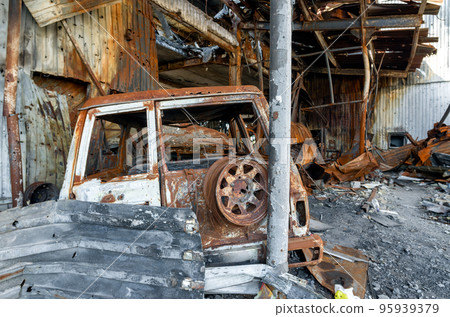 burnt car on the street of the ruined city 95939379