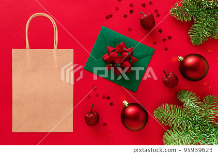 Kraft shopping bag mockup on Christmas styled background..Christmas tree branches, baubles, decorations on red 95939623
