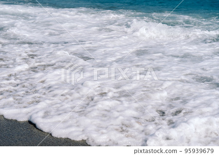 White foamy waves on sandy beach closeup. Seaside on sunny summer day. White foamy waves on sandy beach closeup. Seaside on sunny summer day. 95939679