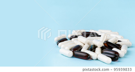 Pharmaceutical pills and vitamins. Medicine or supplement capsules on blue surface. Probiotic, inulin, glucosamine pile. 95939833