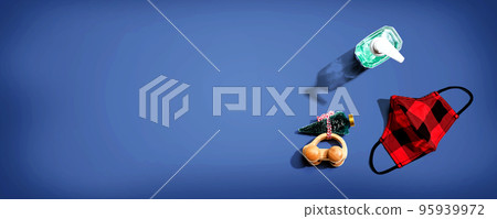 Face mask and a sanitizer bottle with a toy car carrying a Christmas tree 95939972