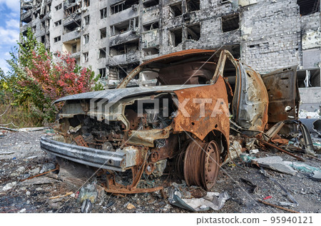 burnt blown up car against the background of a destroyed house in Ukraine 95940121