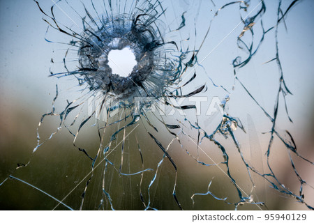 bullet hole in cracked window glass bullet hole in cracked window glass 95940129