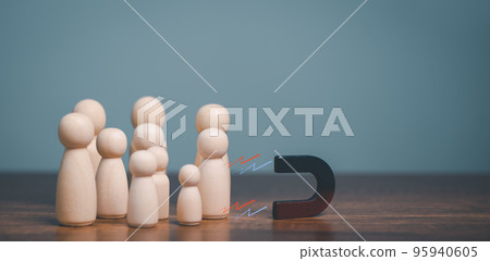 The Power of social media marketing, Magnet pulls wooden doll human figure out of the crowd, Attracting of customers, sales and online traffic, marketing business strategy concept. 95940605