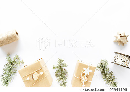 Christmas composition on white surface. Handmade gift boxes, holiday decorations, fir branches. Christmas DIY present concept. Flat lay, copy space 95941196