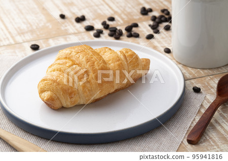 Croissant margarine with coffee cup on wooden background 95941816
