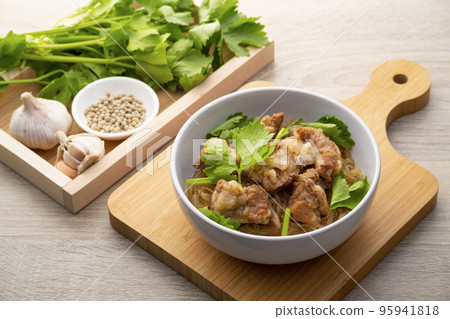 Baked Pork Ribs with Glass Noodles.Thai Style marinade pork by mixing the oyster sauce and soy sauce,topping with celery in white bowl 95941818