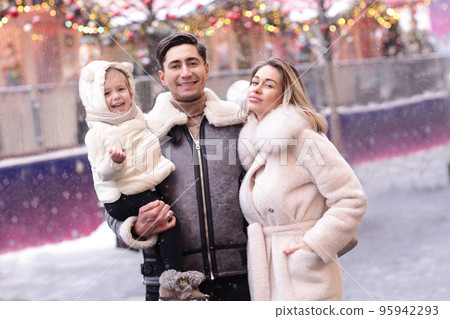 happy family mom dad and baby daughter on Christmas fair in big city shopping mall 95942293