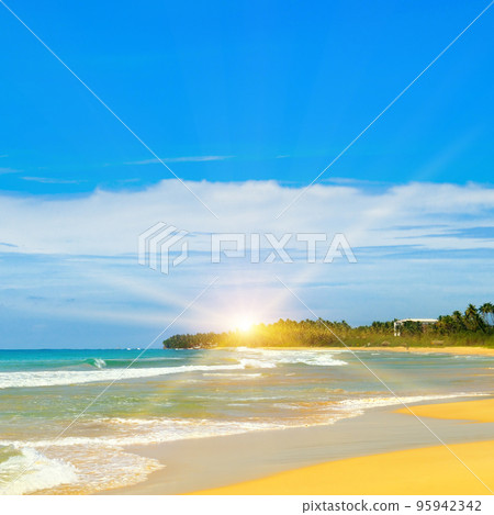 Sandy tropical beach, blue ocean water and bright sun rise. Sandy tropical beach, blue ocean water and bright sun rise. 95942342