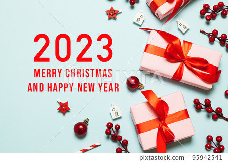2023 Happy New Year and Merry Christmas. Christmas background design with garland, realistic gift box, balls and shiny golden confetti. Christmas poster, holiday banner 2023 Happy New Year and Merry Christmas. Christmas background design with garland, realistic gift box, balls and shiny golden confetti. Christmas poster, holiday banner 95942541