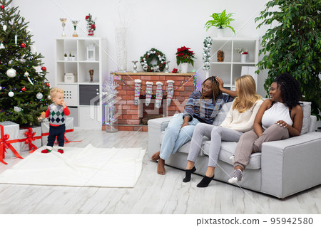 A room in the Christmas mood. Dark-skinned and blonde. 95942580