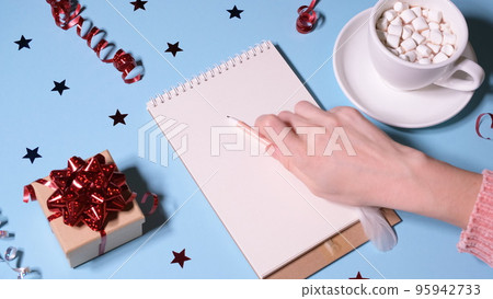Girl or woman writing a letter to Santa Claus and drinking cocoa. New year or christmas holiday concept video. 4K resolution 95942733