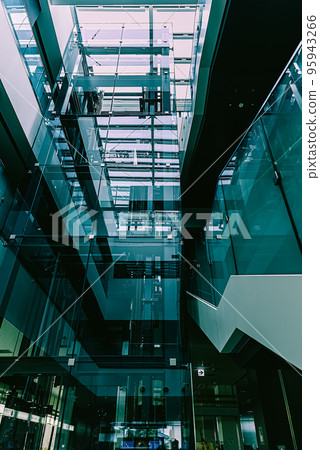 An elevator in an office building that uses a lot of glass 95943266