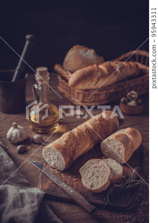 Sliced homemade bread at cutting board at wood table. Bread on wooden tableto 95943311