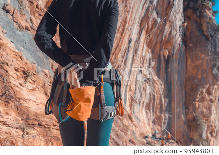 Girl is climbing on the red rocks, leads an active lifestyle. 95943801