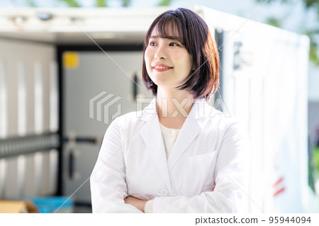 一個穿著白大褂的女人站在卡車前 95944094