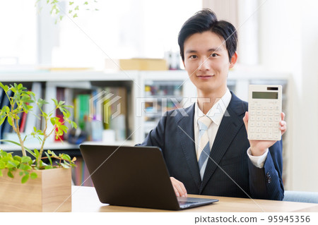 Businessman with a calculator 95945356