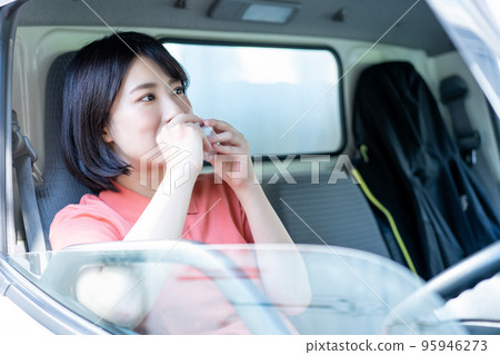 女外賣司機在駕駛座吃飯糰午餐 95946273