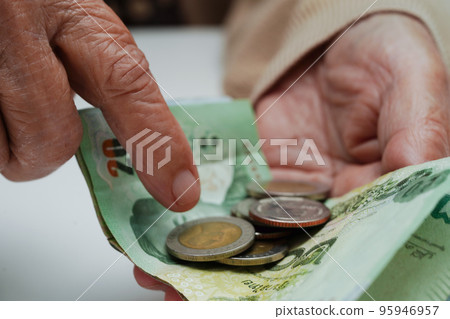 Retired elderly woman counting coins money and worry about monthly expenses and treatment fee payment. 95946957