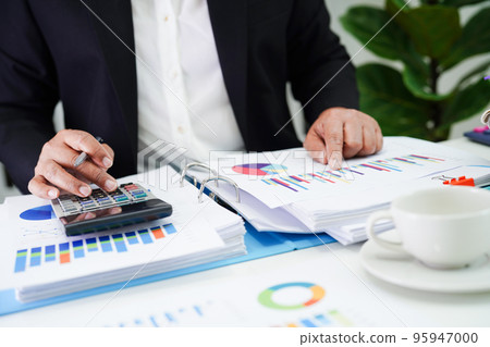 Business woman working and analysis with statistic graph in office. 95947000