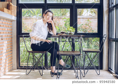 Portrait of young beauty mixed race businesswoman sitting in the modern office and looking to the camera. Conceptual of businesswoman lifestyle. Portrait of young beauty mixed race businesswoman sitting in the modern office and looking to the camera. Conceptual of businesswoman lifestyle. 95948580