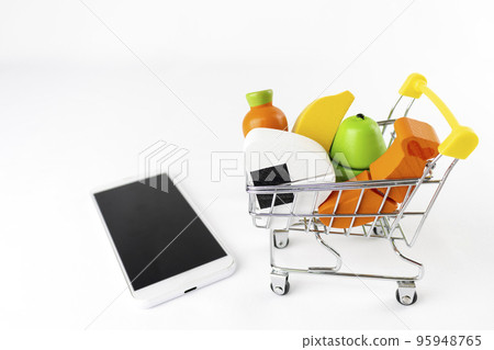 Shopping cart and wooden toy food and smart phone. Image of shopping at an online supermarket 95948765