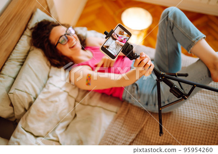 Woman blogger videotapes her vlog at home and speaking about Vaccine for covid-19. Woman blogger videotapes her vlog at home and speaking about Vaccine for covid-19. 95954260