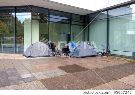 Tents of homeless people near the business center. The global problem of the homeless. Tents of homeless people near the business center. The global problem of the homeless. 95957242