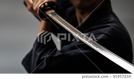 A person holding a Japanese sword A person holding a Japanese sword 95957839