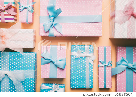 A lot of Christmas gift boxes in colored paper decorated on table, Top view close up. Many present New Year gift 95958504