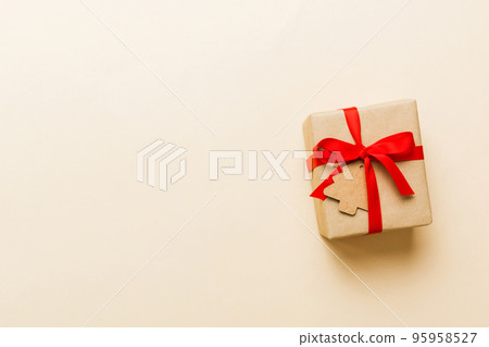 wrapped christmas or other holiday handmade present in paper with colored ribbon. Present box, decoration of gift on colourfull table, top view with copy space wrapped christmas or other holiday handmade present in paper with colored ribbon. Present box, decoration of gift on colourfull table, top view with copy space 95958527