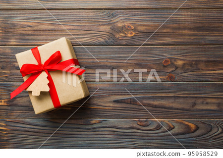 wrapped christmas or other holiday handmade present in paper with colored ribbon. Present box, decoration of gift on colourfull table, top view with copy space wrapped christmas or other holiday handmade present in paper with colored ribbon. Present box, decoration of gift on colourfull table, top view with copy space 95958529